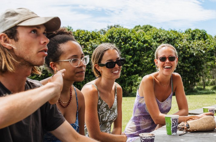 Embark on a private crop-to-cup coffee tour at Zentveld's Farm & Roastery: In Newrybar, Australia A group of people at the table enjoying their freshly brewed coffee during the coffee farm tour
