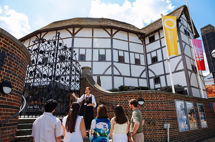 The guide and tourists on the excursion near the Shakespeare's Globe, theater