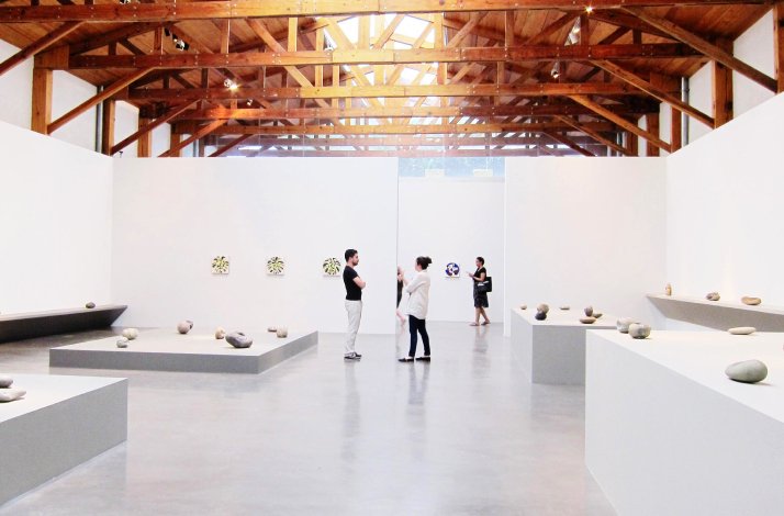 People browsing through sculptures and paintings displayed at the Kurimanzutto Gallery