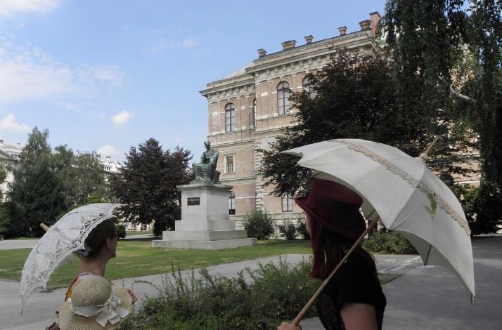 Two people standing in front of a castle with umbrellas on a Zagrebarium tour. 
