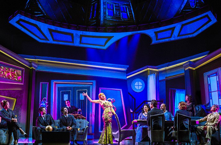 Beetlejuice dinner party scene with bold costumes and quirky characters.