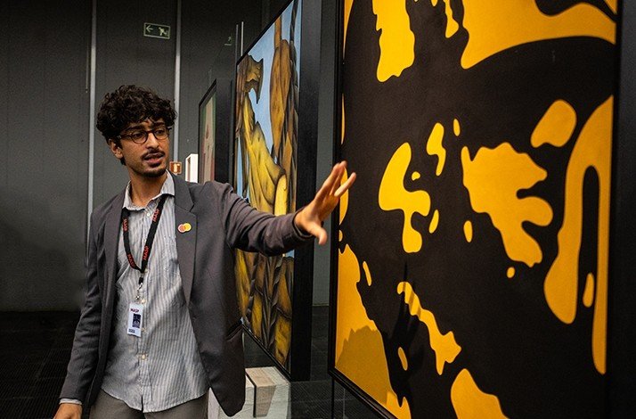 Male curator of the São Paulo Museum of Art presents about one of the exhibited artworks during after-hours visit.