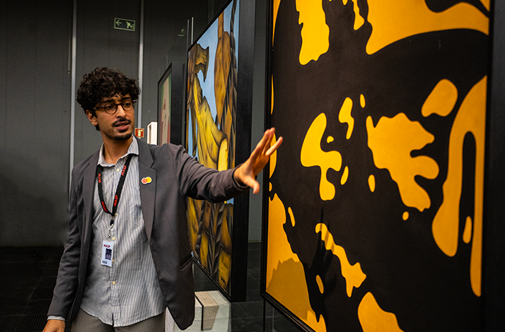 Male curator of the São Paulo Museum of Art presents about one of the exhibited artworks during after-hours visit.