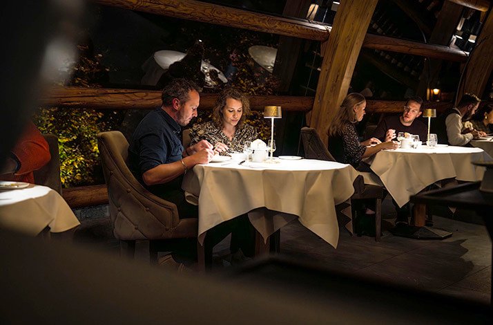 A couple is sitting at the table and having dinner at the Orangerie De Pol