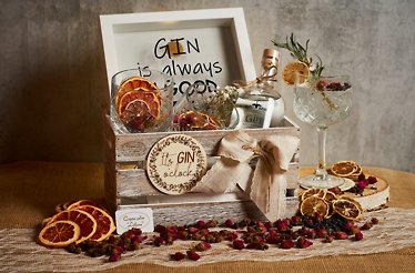 Bijeli Gusak giftbox containing a bottle of gin, 2 glasses, a souvenir photo frame, all decorated with dried citrus slices.