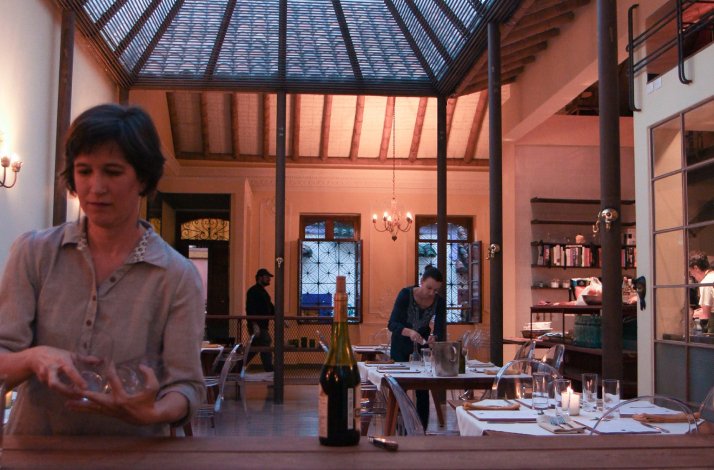 The interior of a restaurant in Bogora, displaying waiters setting  tables for guests