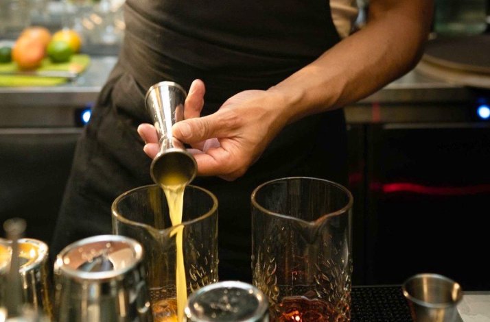 Hands of a host whipping up tasty cocktails with viche, a cherished drink originating in Colombia's Black communities