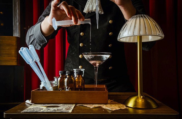 Bartender in Backdrop doing a mixology crafting cocktails