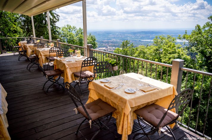 Open air dining area of restaurant Albergo Colonne overlooking a garden and the city.