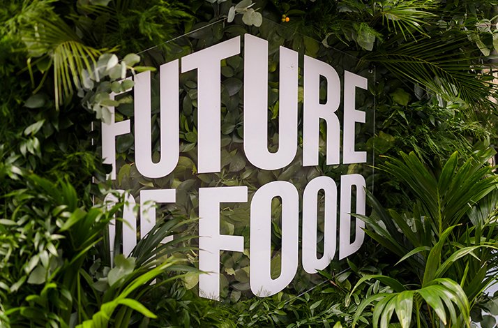 Large Future of Food sign surrounded by lush green plants.
