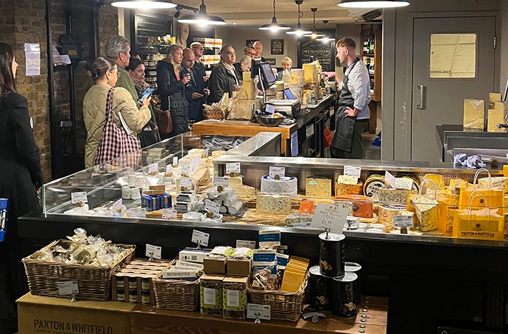 A busy interior of a Paxton & Whitfield cheesemonger shop.