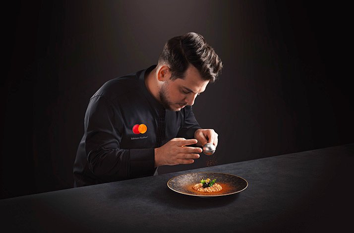 The chef wearing the uniform with MC logo is preparing the unique dish.