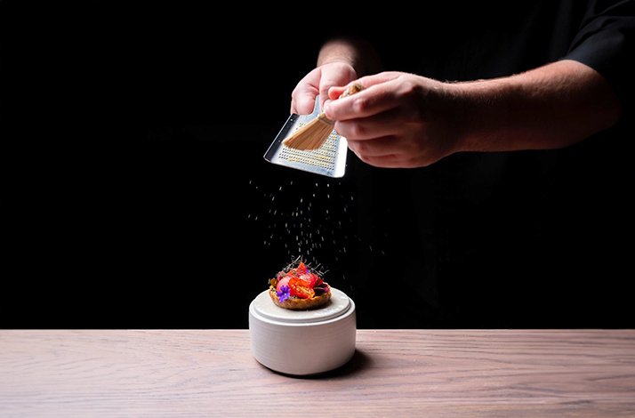 A waiter striping cinnamon to a dessert Moonrise 