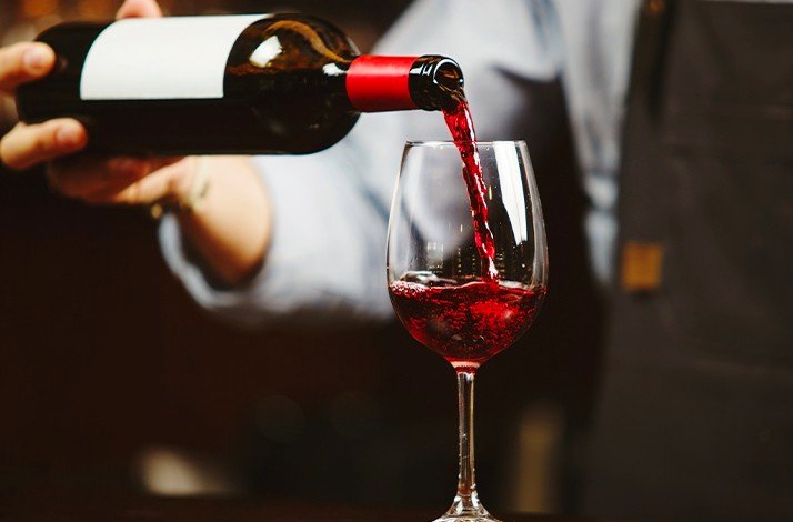 A waiter pouring wine into a glass at Tierra Mendocina Wine Bar