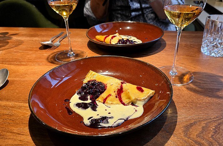 Imperial Caviar 'Elsa' Osetra with Bavarian pretzels, shrimp amuse-bouche, and 'Altes & Syriens' wine bottle on a wooden board at a Munich tasting experience.