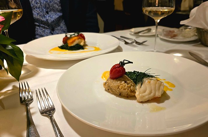 A white plate displaying a variety of cooked dishes at the Restaurant Nymphenburger Hof.