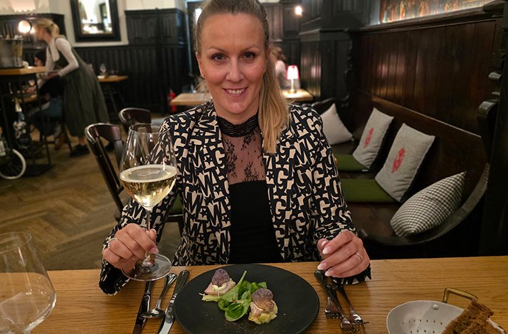 Munich restaurant expert Bianca Murthy holding a glass of wine.