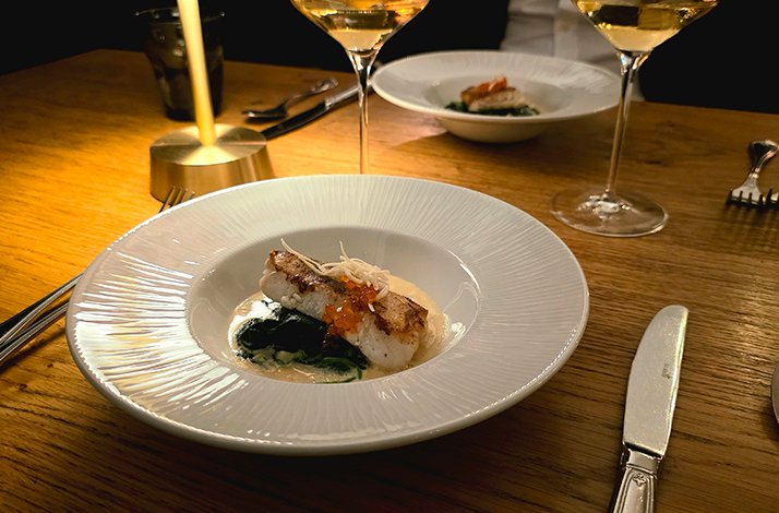 Fish dish served on the white plate.