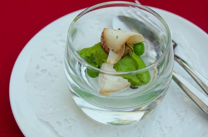Green pea purée topped with sliced mushrooms served in a glass cup, showcasing Huber's off-menu 5-course surprise tasting menu.