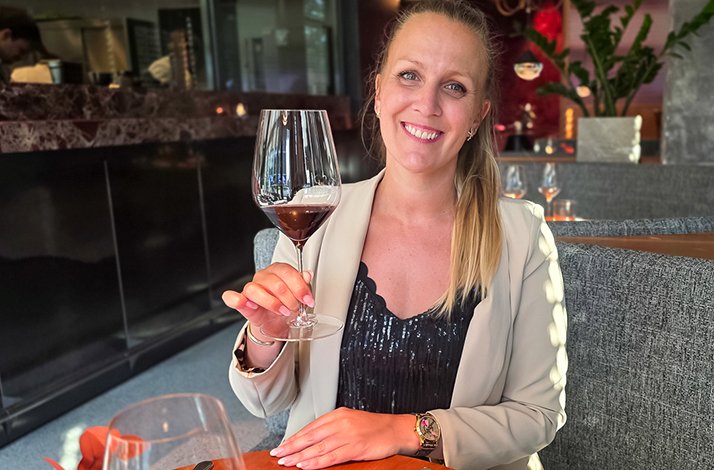 Bianca Murthy at a Munich restaurant with a glass of wine.