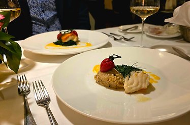 A white plate displaying a variety of cooked dishes at the Restaurant Nymphenburger Hof.