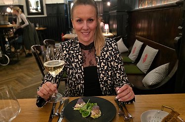 Munich restaurant expert Bianca Murthy holding a glass of wine.