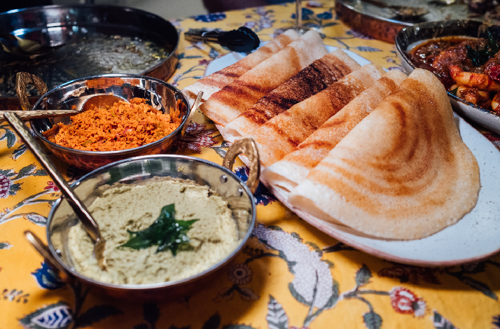 Traditional South Indian meal with dosa and accompaniments.