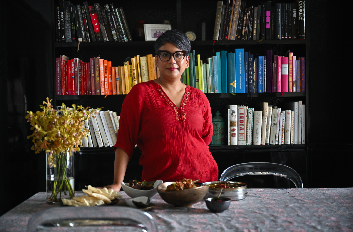 Vasunthara Ramasamy in front of her book shelves at her home. 