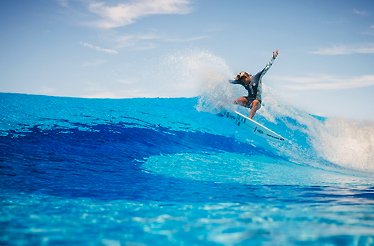 Person riding a wave during surf session at O2 Surftown in Munich, Germany.