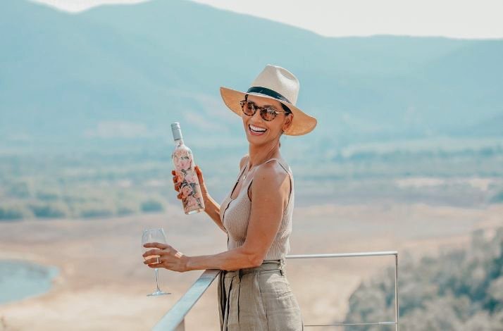 A person holding a bottle of Viña VIK wine and a wine glass