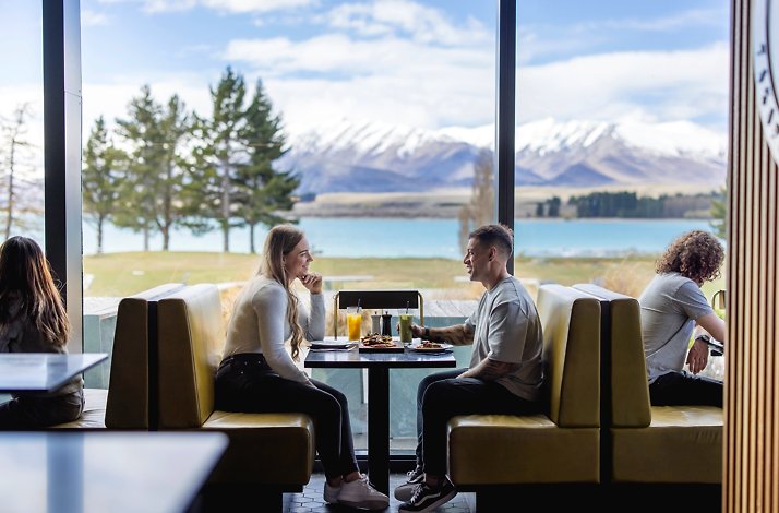 A couple dines at Dark Sky Diner overlooking Lake Tekapo and the snow-capped Southern Alps in New Zealand.