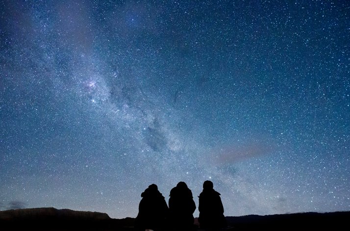 Three people stargazing on a private guided astronomy excursion with Dark Sky Project