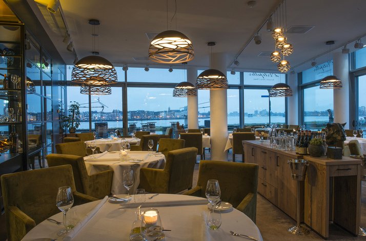 A dining area showcasing tables and chairs at De Ertepeller.