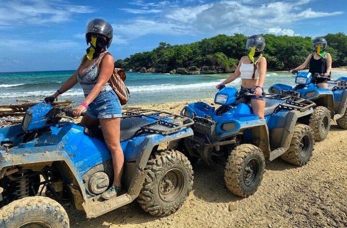 Girls sitting on a blue ATVs during Tour through Jamaica's Landscapes