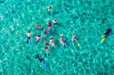 Aerial drone view of people snorkeling in the Caribbean.