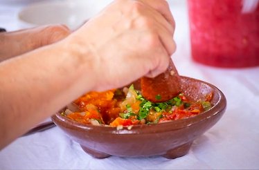 A participant of culinary classes mixing the ingredients with special tool