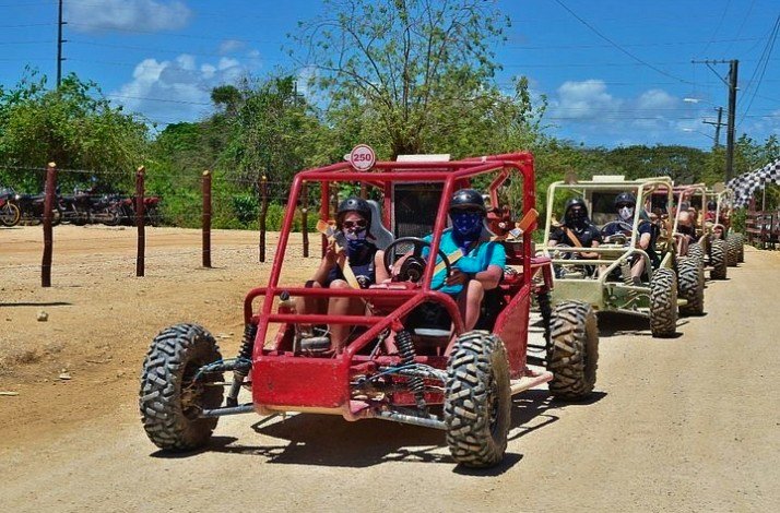 A group of people joyfully riding together on a four-wheeler