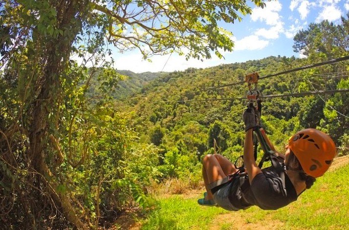 A person enjoying a zipline ride while wearing a helmet at the Anamuya Mountains.