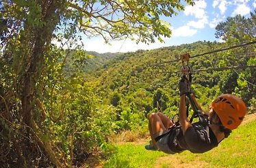 A person enjoying a zipline ride while wearing a helmet at the Anamuya Mountains.