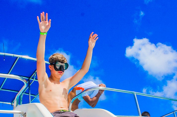 A boy prepares to slide into the ocean.