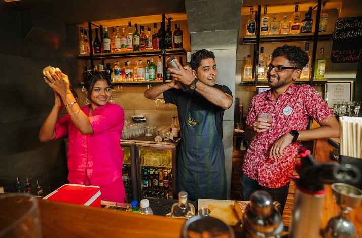 Tourists mixing and drinking cocktails at a restaurant in Panaji, India.