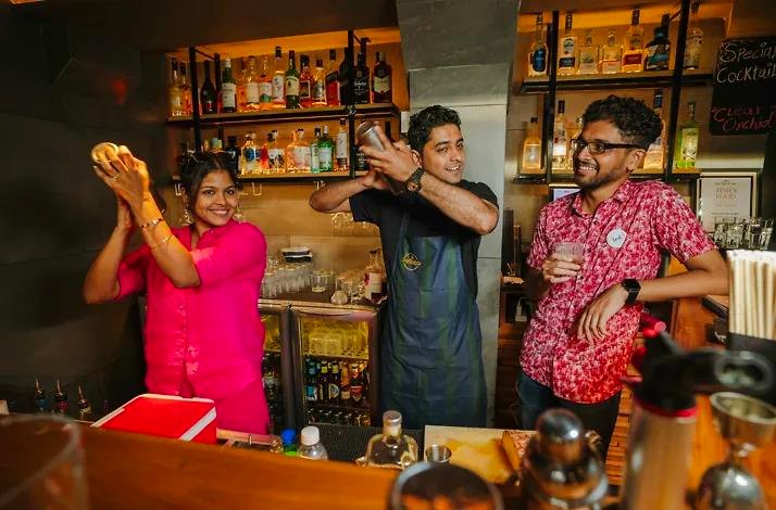 Tourists mixing and drinking cocktails at a restaurant in Panaji, India.