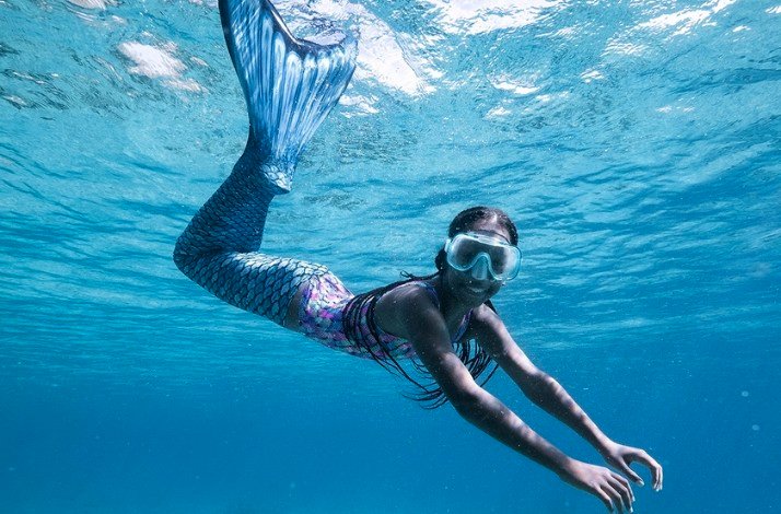 A women is swimming in the ocean with mermaid tail at Marie Pampoen 