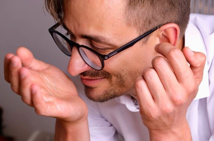 A male model smelling unique perfume by Crispy from his own hand