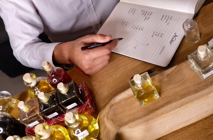 Samples of Crispy perfume on the table and male model making notes in a writing pad