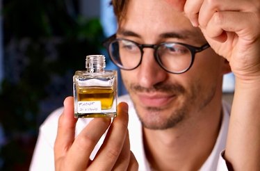 A male model holding an example of unique eco-friendly perfume by Crispy