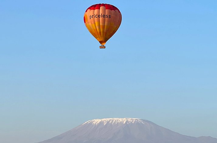 The hot air balloon with the branded Priceless logo is floating over the Mt. Kilimanjaro.