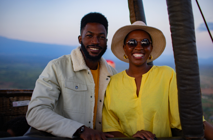 A man and woman enjoy hot air balloon safari tour over the Amboseli ecosystem.