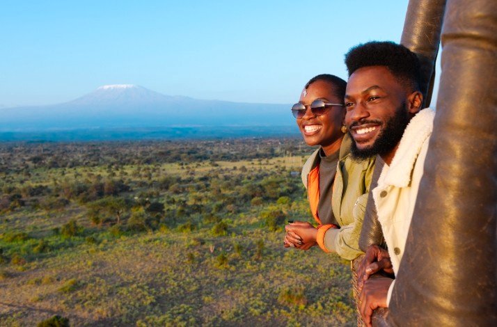 Soar over Amboseli National Park on the ultimate hot air balloon adventure: In Kajiado, Kenya A man and woman enjoy the bird's eye views of African wildlife at hot air balloon safari tour over the Amboseli ecosystem.