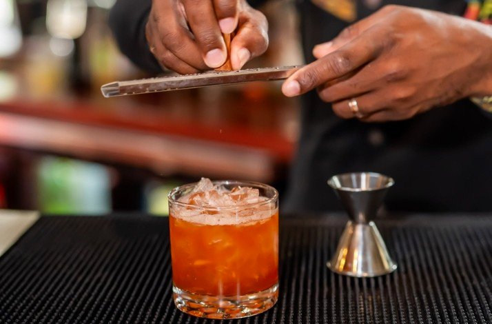 A bartender preparing the final details for a cocktail